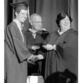 ake Detwiler posing with school board members Joe Dieringer and Susan McGuire and an unidentified graduate getting a congratulatory hug.