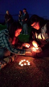 Carolynn Williams and Makayla Weishaupt light candles for the Ellis family after the prayer vigil at EastPointe Foursquare Church.