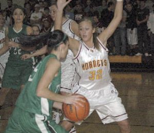 Megan McKune slows down a Tumwater Thunderbird during the Hornets’ 62-44 season-opening win.