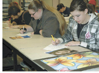 Lacy Smith critiques her own work before moving on to examine the work of her fellow students during a recent Enumclaw High art class.