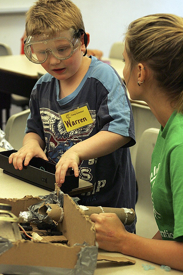 Warren Brown works with instructor Megan Lenihan Friday to build a pin ball machine out of recycled materials.