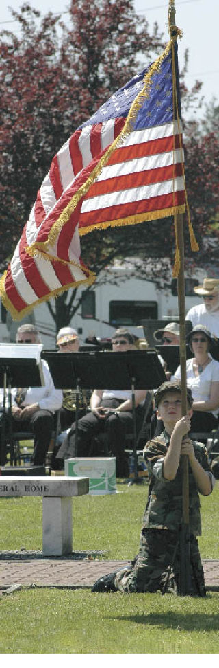 Pvt. Justin Pitzer from Enumclaw’s Carbon Glacier Young Marines maintains his position as a gentle breeze unfurls the  flag during the Veterans of Foreign Wars Post 1949’s  Memorial Day ceremony Sunday afternoon in Enumclaw. A large crowd gathered at the Veterans’ Memorial near state Route 410 for the hour-long tribute. The day’s events  included the VFW Honor Guard