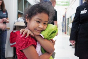 Tayvonna hugs her new winter coat close after East Pierce firefighters make sure it's a good fit.