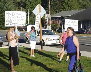 Councilwoman Pat Pepper walks past about a dozen residents expressing their frustration with the Black Diamond City Council