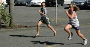 Maggie Poulin gives friend Kennedy VanHoof some encouragement as they make it to the finish line of the Enumclaw Street Fair 5K Saturday.