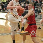 Enumclaw junior forward Griff Webb drives to the basket over forward Trevor Hoffman from Kennedy Catholic. Photo by Dennis Box.