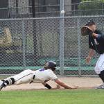 A Spartan dives back to first, racing a ball thrown toward Bonney Lake&rsquo;s first baseman in a hotly contested game. Photo by Ray Still