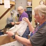 Dede Trowbridge and Mike Gordon go through donations at the Pennies from Heaven thrift store, run by Plateau Outreach Ministries. POM promotes volunteer opportunities through the Justserve.org website. Photo by Ray Still