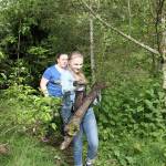 Ella Moyer and Alyssa Headley collect wood to create a platform for pulled plants to decompose on, instead of rerooting into the ground. Photo by Ray Still