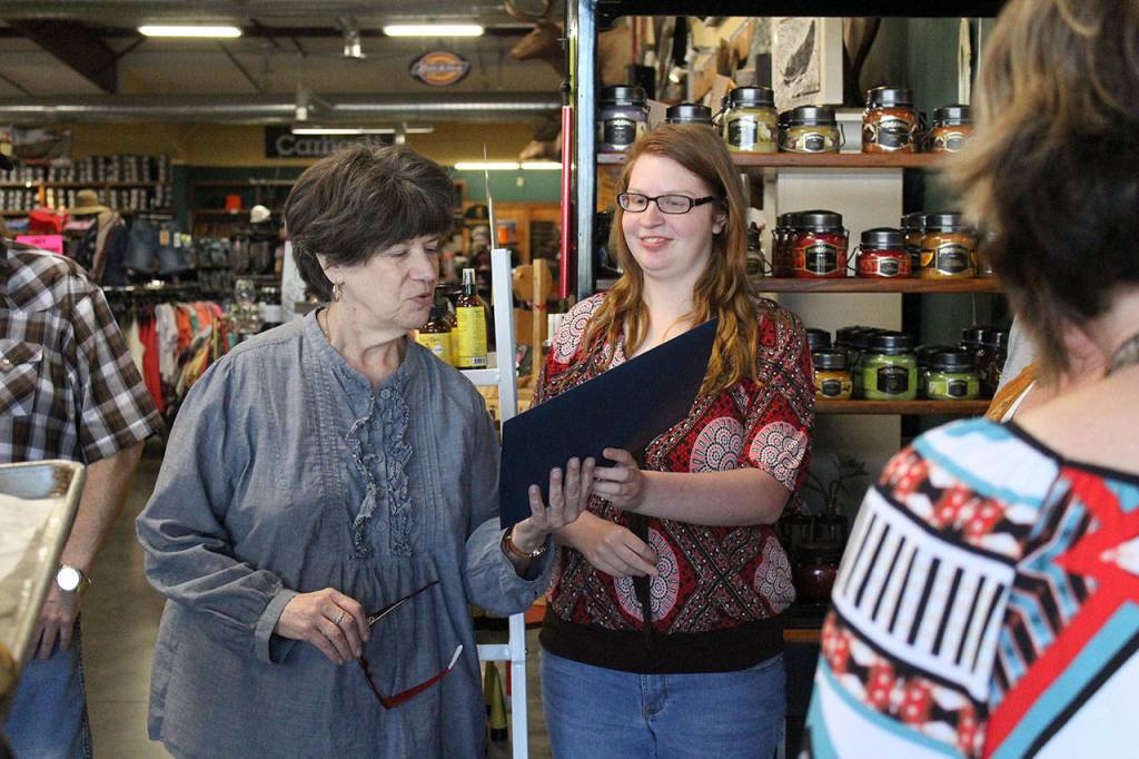 Hornet Kaylee Sines tanks her mentor, Debbie Veltung, at Work Sports and More. Photo by Ray Still