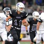 Sumner High quarterback Austin Grondahl picks up yardage during last weeks rout of visiting Olympia. Photo by Vince Miller/www.vincemillerphoto.com