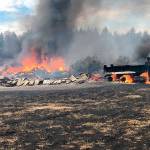 The 12-acre fire, exacerbated by dry grass and winds, destroyed two barns, a mobile home, two cars, a dump truck, a panel truck, and other buildings and vehicles. Photo courtesy East Pierce Fire and Rescue