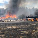 The 12-acre fire, exacerbated by dry grass and winds, destroyed two barns, a mobile home, two cars, a dump truck, a panel truck, and other buildings and vehicles. Photo courtesy East Pierce Fire and Rescue