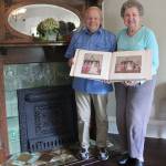 Kay (Borell) Skogan and her husband Robert holding up their original wedding album in front of the Le Sorelle Inns fireplace, suspected to be the original. Photo by Ray Miller-Still