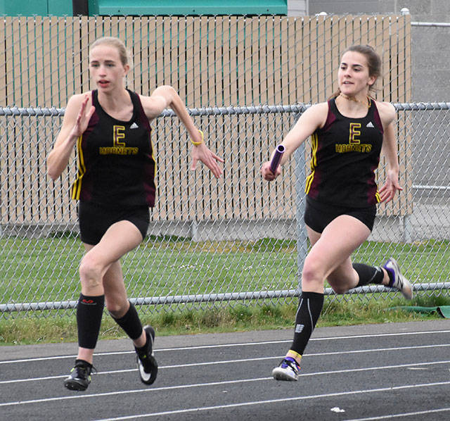 Gracie Neu, holding the baton, and Johanna Brown make up one-half of Enumclaw Highs state-leading 4x400 relay team. File photo by Kevin Hanson