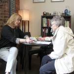 Enumclaws Senior Center manager Jobyna Nickum goes through some paperwork with a center member in her new ADA-accessible office. Photo by Ray Miller-Still