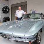 Alan Gamblin, who took over his fathers dealership in 1985, stands in his car shop next to his personal 1964 Corvette. Photo by Ray Miller-Still