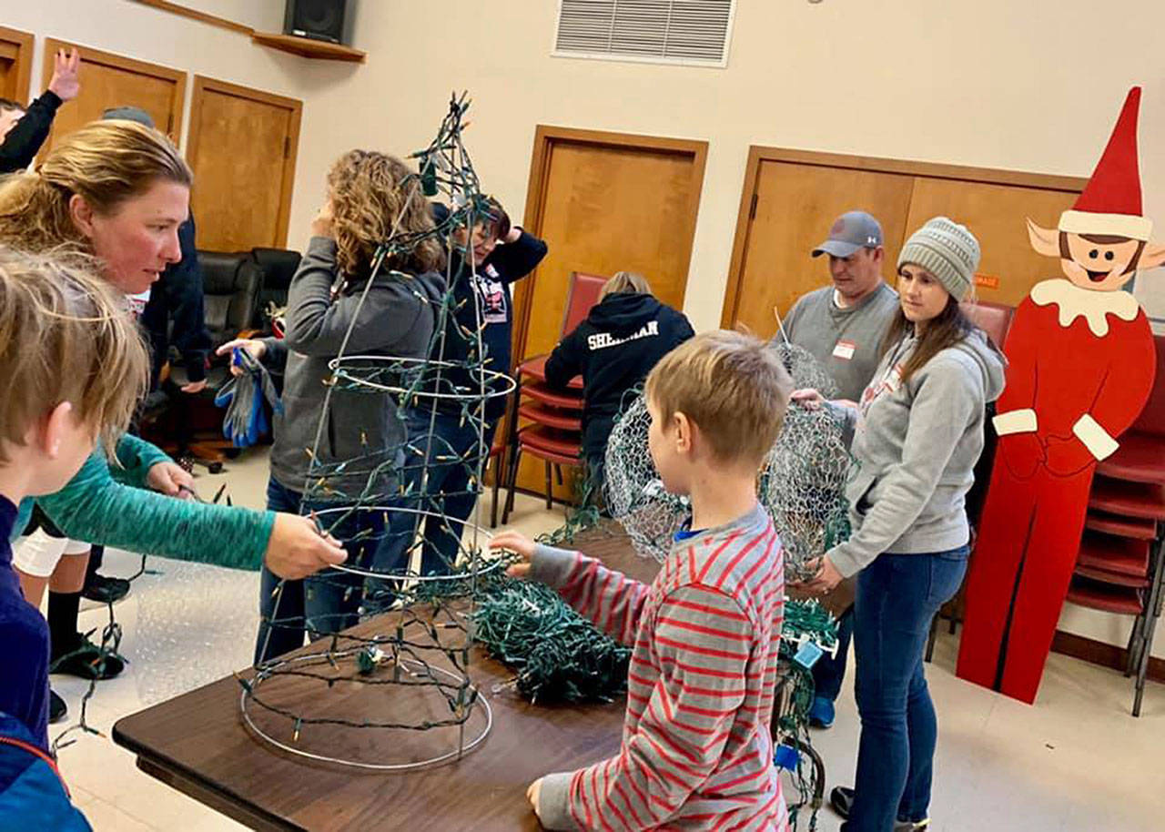 Volunteers of all ages gathered inside Buckleys City Council chambers last year to prepare lights and decorations for the first-ever Merry on Main event on Main Street. Contributed photo