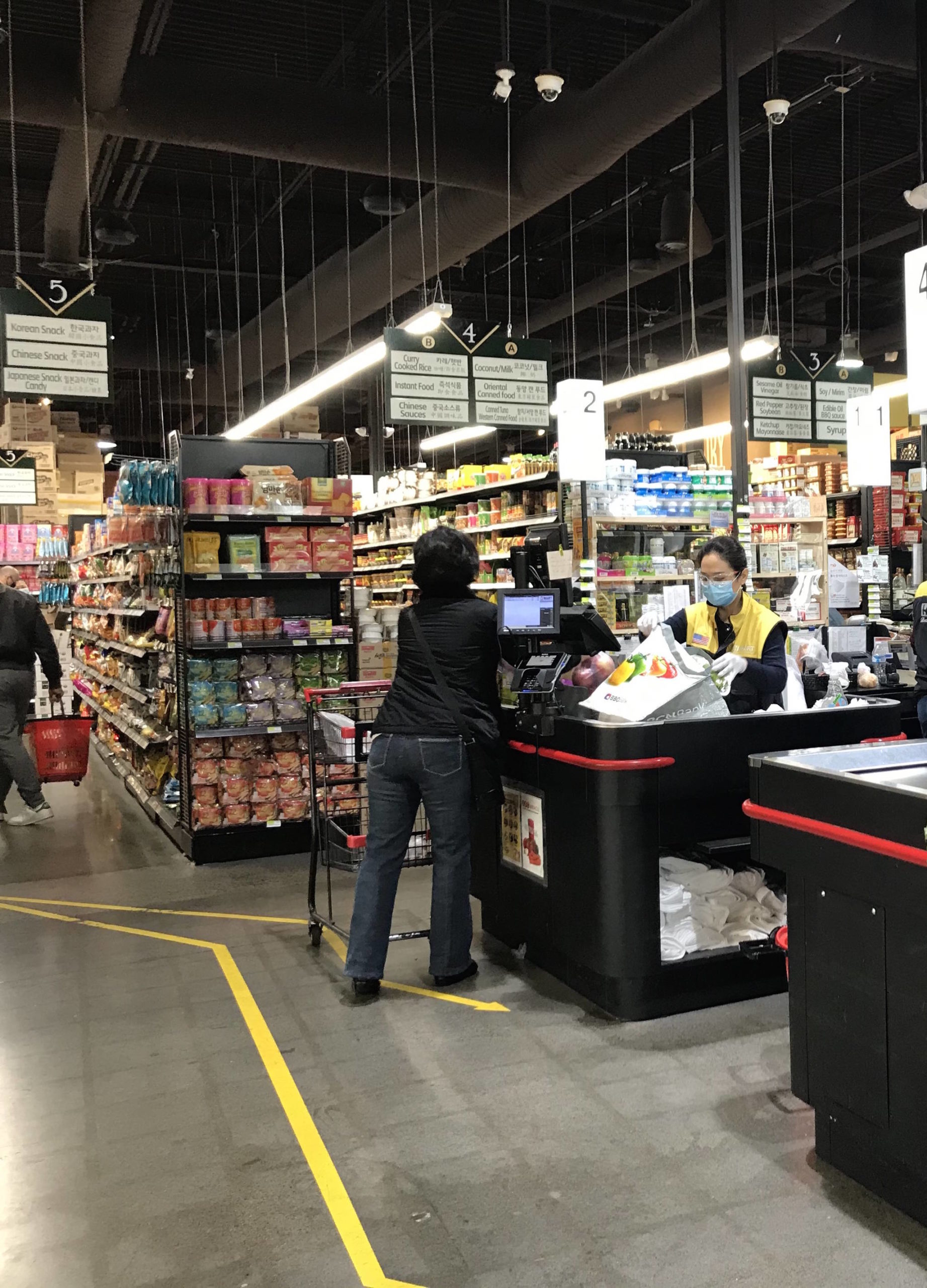 A cashier at H Mart in Bellevue rings up a customer on March 28. Samantha Pak/staff photo
