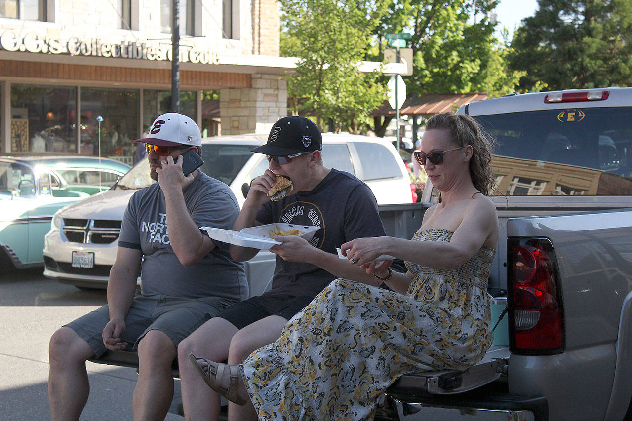Kaden Loop, participating in the downtown cruise by getting some food from a local restaurant, is chowing down on a bleu cheeseburger from The Lee. Photos by Ray Miller-Still