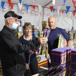Pastor Jim Dunn shows a couple some safe fireworks for their little ones this upcoming Independence Day. Sponsored by the local St. Baptist Church, this TNT Firework stand has been here 15 years, and all proceeds go toward church sports programs. Photo by Ray Miller-Still