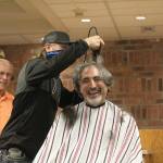 Enumclaw Mayor Jan Molinaro was shaved by local barber and former City Councilman Chuck Anselmo, who oversaw four Enumclaw High School graduates and wrestlers  Drew Krehbiel, Brandon Cromier, Aiden Carroll (pictured), and Cole Bower  as they made first contact with the mayors shaggy mane. Photo by Ray Miller-Still