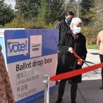 With members of the City Council looking on, Black Diamond Mayor Carol Benson cuts a ceremonial ribbon, opening a ballot drop box at the library. Photo by Kevin Hanson