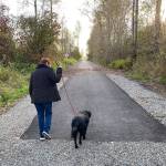 A new paved trail, provided by the city of Enumclaw, extends to a point just shy of the city limits. Here, a trail user and canine companion turn and head back toward Battersby Avenue. Photo by Kevin Hanson