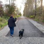 A new paved trail, provided by the city of Enumclaw, extends to a point just shy of the city limits. Here, a trail user and canine companion turn and head back toward Battersby Avenue. Photo by Kevin Hanson