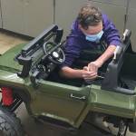 Enumclaw's Eli Murphy spent an estimated 75 hours modifying an electric car for a Colorado boy with special needs (pictured here). The local photos show Eli modifying the vehicle's seatbelt. Contributed photo