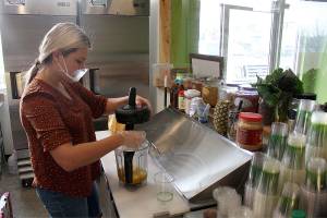 Health Bar owner Heidi Hawkinson preparing a mango smoothie. Photo by Ray Miller-Still