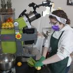 Corrine Hennessy getting ready to load up their cold-press juicer, Lucy Juicy. Photo by Ray Miller-Still