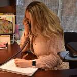 Melissa Holt, recreation programmer at the Senior Activity Center, answers voicemails from people hoping to get vaccinated Sunday. Photo by Alex Bruell