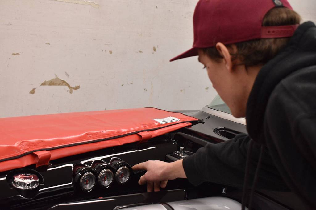 Josh Sanders points out a set of custom gauges in the engine bay of the 1959 Corvette that he fashioned to resemble similar gauges in the cars dashboard during a tour of the Enumclaw shop on March 5. Photo by Alex Bruell