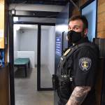Enumclaw Police Correctional Officer Tyler Ewalt holds open the door to a holding cell at the police departments jail the afternoon of April 5. The cell, while not the one he rushed to when an inmate attempted suicide last month, is nonetheless where inmates in crisis are typically held. Photo by Alex Bruell