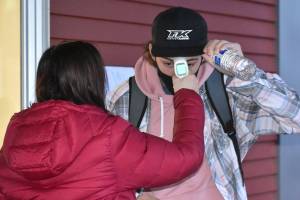 Enumclaw High School will start bringing students back full time May 3. Pictured here is a student receiving a temperature check in February, when the district started allowing students back into classrooms with mix of in-person and at-home learning models. Photo by Kevin Hanson
