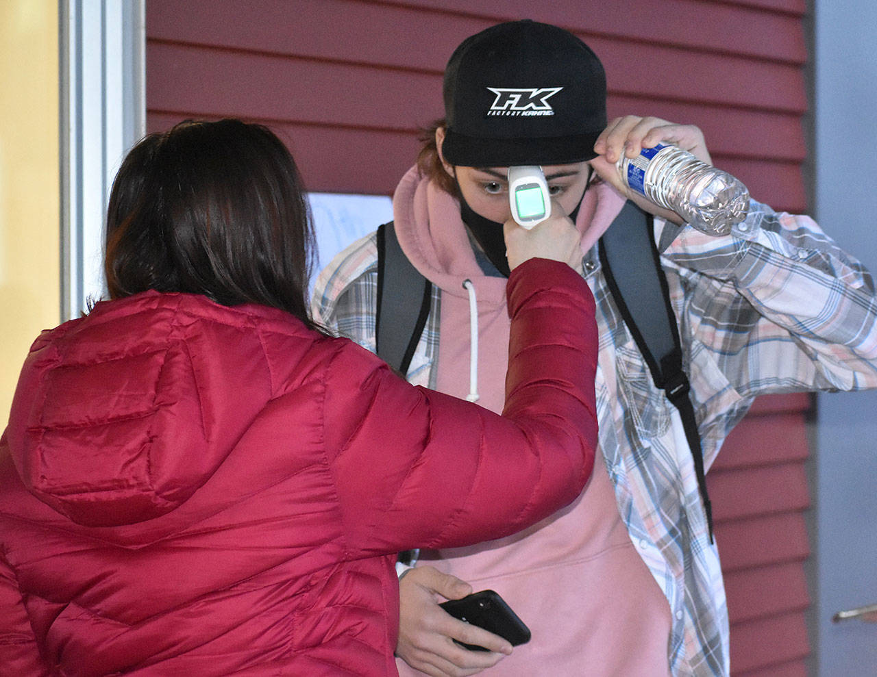 Enumclaw High School will start bringing students back full time May 3. Pictured here is a student receiving a temperature check in February, when the district started allowing students back into classrooms with mix of in-person and at-home learning models. Photo by Kevin Hanson
