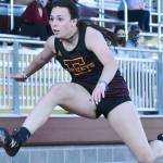 Sunny skies greet track and field athletes at Arrow Lumber Stadium Thursday afternoon. Enumclaw High made the trek across the river to take on their Buckley hosts, but headed home on the short end of the scoring. Here, Enumclaw's Ellie DeGroot clears a hurdle on the way to victory; also, a trio of White River runners complete a first lap on the track. Photo by Kevin Hanson