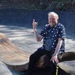 John Hillding, wearing a bacon and eggs shirt, sits atop a giant piece of concrete bacon which is part of his art installation / skatepark combination in Wilkeson. Photo by Alex Bruell
