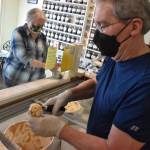Toby Wenham scoops a cone of ice cream while his wife Peggy inspects the tip jar at Sweet Necessities. Photo by Alex Bruell