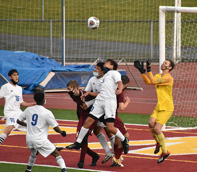 With Hornets and Trojans battling for position in front of the net, White River goalkeeper Nick Panin prepares to make a save during Thursday nights contest on the White River High campus. In an exciting contest that went into a shootout, the visitors from Fife High escaped with a win to take the postseason title. Photo by Kevin Hanson