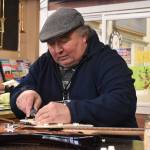 David Bozich repairs a guitar at the front desk of Enumclaw Music. Photo by Alex Bruell