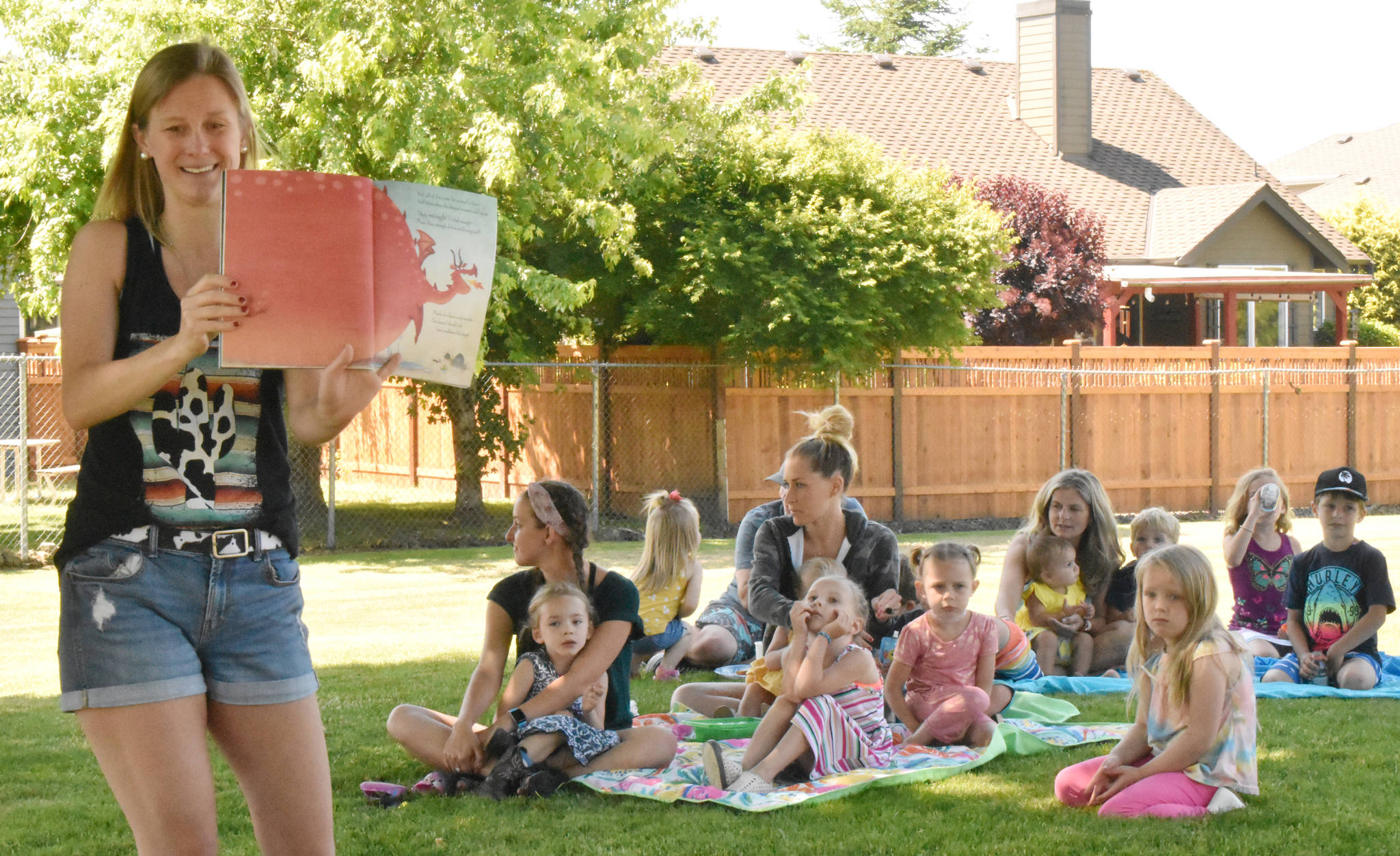 PHOTOS BY KEVIN HANSON Every Tuesday at 11 a.m., Aubree Axelson can be found at Enumclaws Flensted Park, reading stories to kids and their parents. Its a volunteer effort by Axelson, who spends most of the year in front of youngsters while serving as a kindergarten teacher at Elk Ridge Elementary in Buckley. The Tuesday events are a drop-in affair, no cost and no need to register.