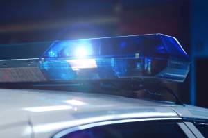 Police at night in the car with blue siren flasher. Siren on police car flashing, close-up. Police light and siren on the car in action. Emergency flashing police siren during night period. Police signal flasher isolated.