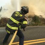 Volunteer firefighter Tristan Wisont works at putting out flames from the brush fires caused by downed power lines near Enumclaw Thursday, Aug. 5. Photo courtesy Enumclaw Fire Chief Randy Fehr.