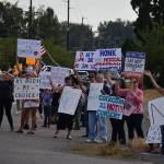 People hold up signs in protest of Gov. Jay Inslees latest proclamations during a Rally for Medical Freedom in Buckley Wednesday. Photo by Alex Bruell.