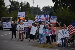People hold up signs in protest of Gov. Jay Inslees latest proclamations during a Rally for Medical Freedom in Buckley Wednesday. Photo by Alex Bruell.