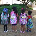 A group of kids shows off backpacks from the Y Social Impact Centers school supplies drive. Photo provided by Y Center Office Manager Christine Adkins.