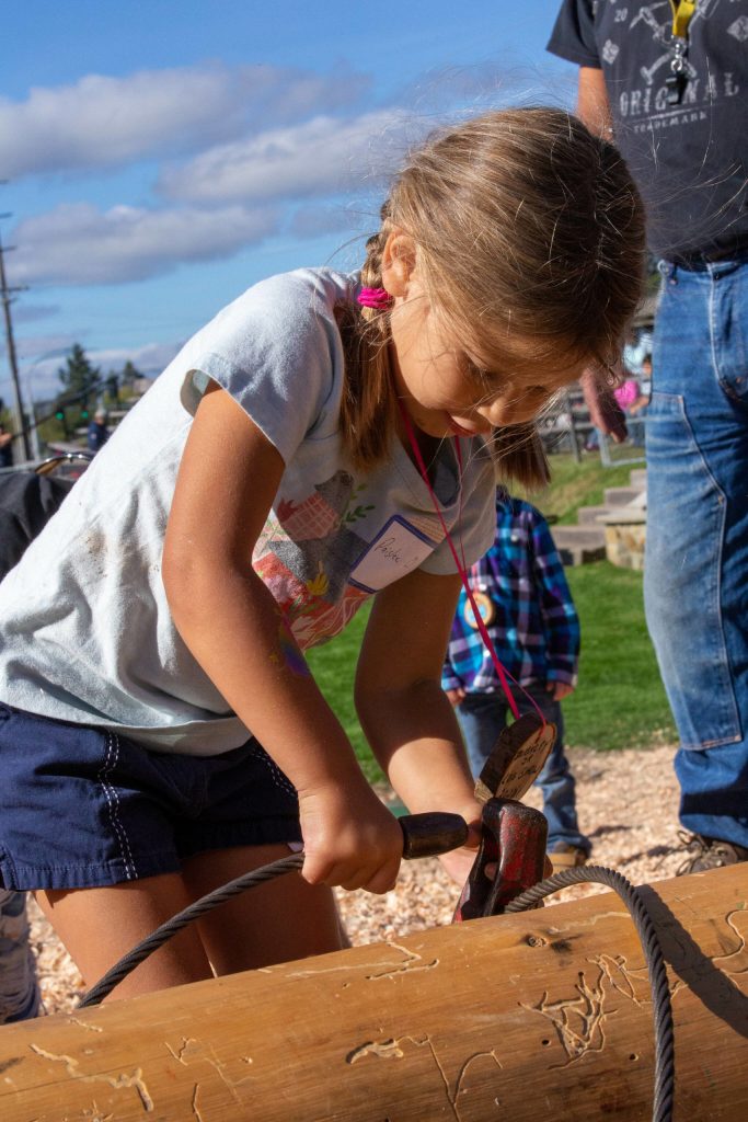 Photo by Ashley Britschgi 
Paislee Olson sets a choker around a log of wood.