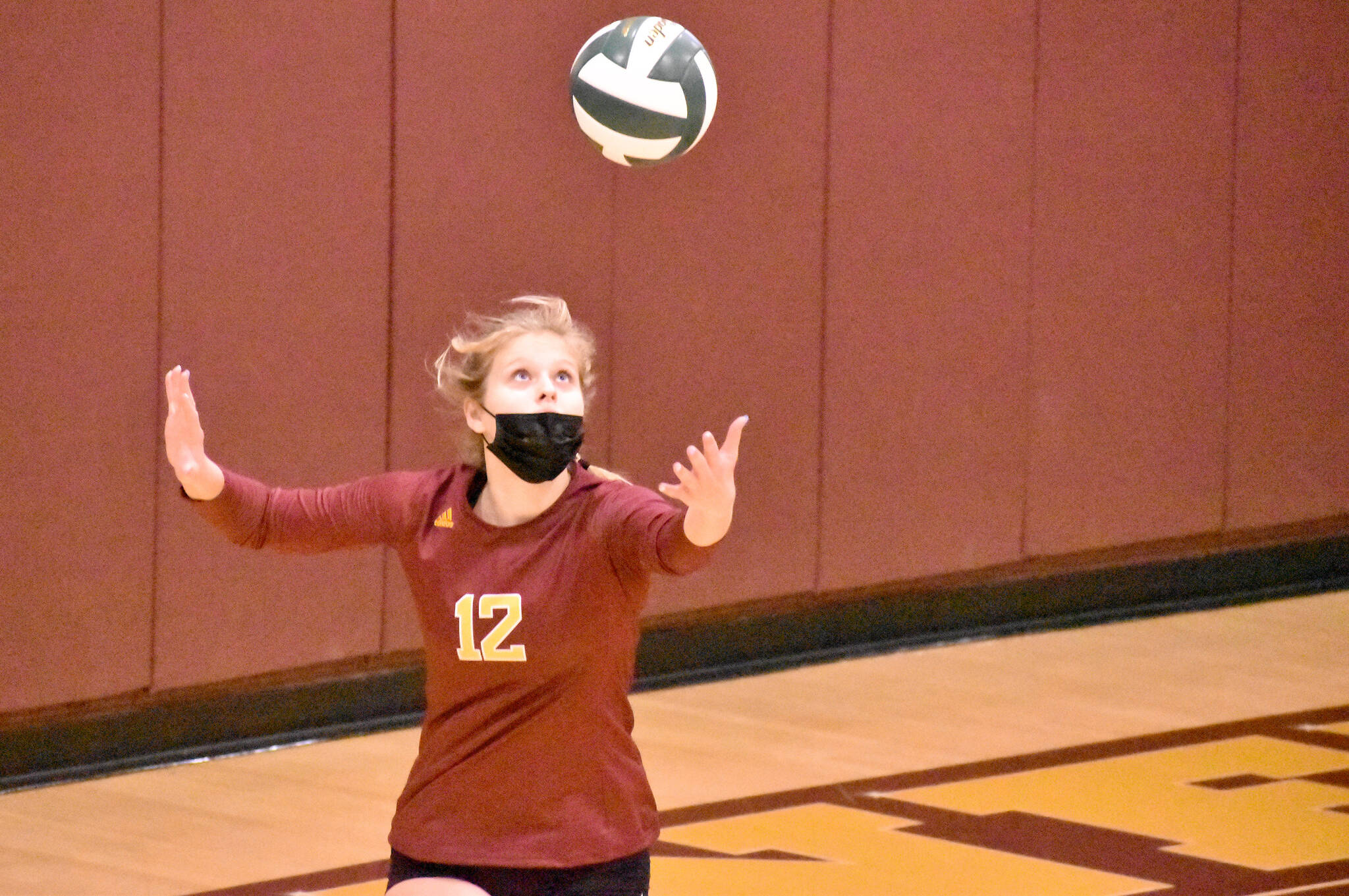Macy Furtwangler (#12) prepares to launch a serve. Photo by Kevin Hanson.